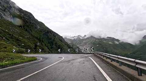 Eine Kehre der Auffahrt zum Grimselpass bietet die Möglichkeit, kurz anzuhalten, und einen Blick auf den Furkapass, den Rhône-Gletscher und das berühmte Hotel Belvedérè zu riskieren.