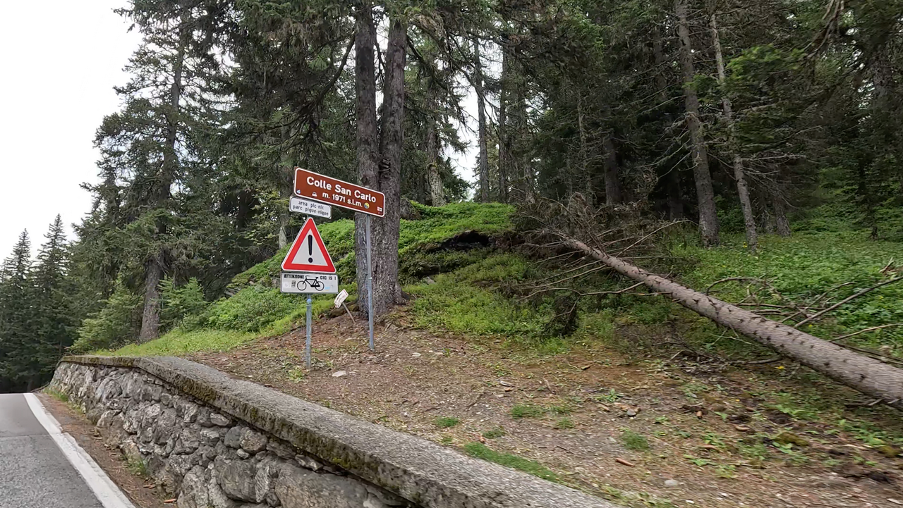 Die Passhöhe des Colle San Carlo ist, trotz fast 2000 Höhenmetern, gut bewaldet. Parkbuchten, ein Restaurant samt Hotel bieten Möglichkeiten eine Pause einzulegen.
