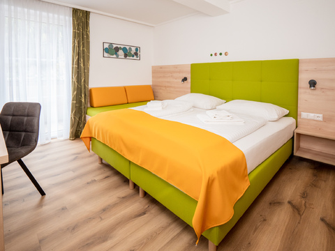 Das Familienzimmer ist mit zwei Doppelbetten und mit Badezimmer ausgestattet. Einen Balkon mit einer schönen Aussicht auf den Afritzer See.