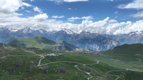 Malerisch eingebettet in ein Hochplateau liegt Alpe d'Huez, Mekka der Fahrradfahrer – Blick von der Westrampe des Col de Sarenne.