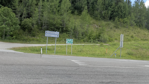 An der Landstraße steht ein Passschild – obwohl die eigentliche Passhöhe etwas abseits der Landstraße liegt.