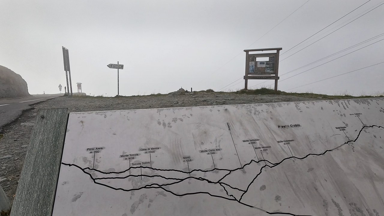 Die Passhöhe bestimmt eine große Steintafel auf der die Gipfel der umliegenden Berge beschrieben sind.