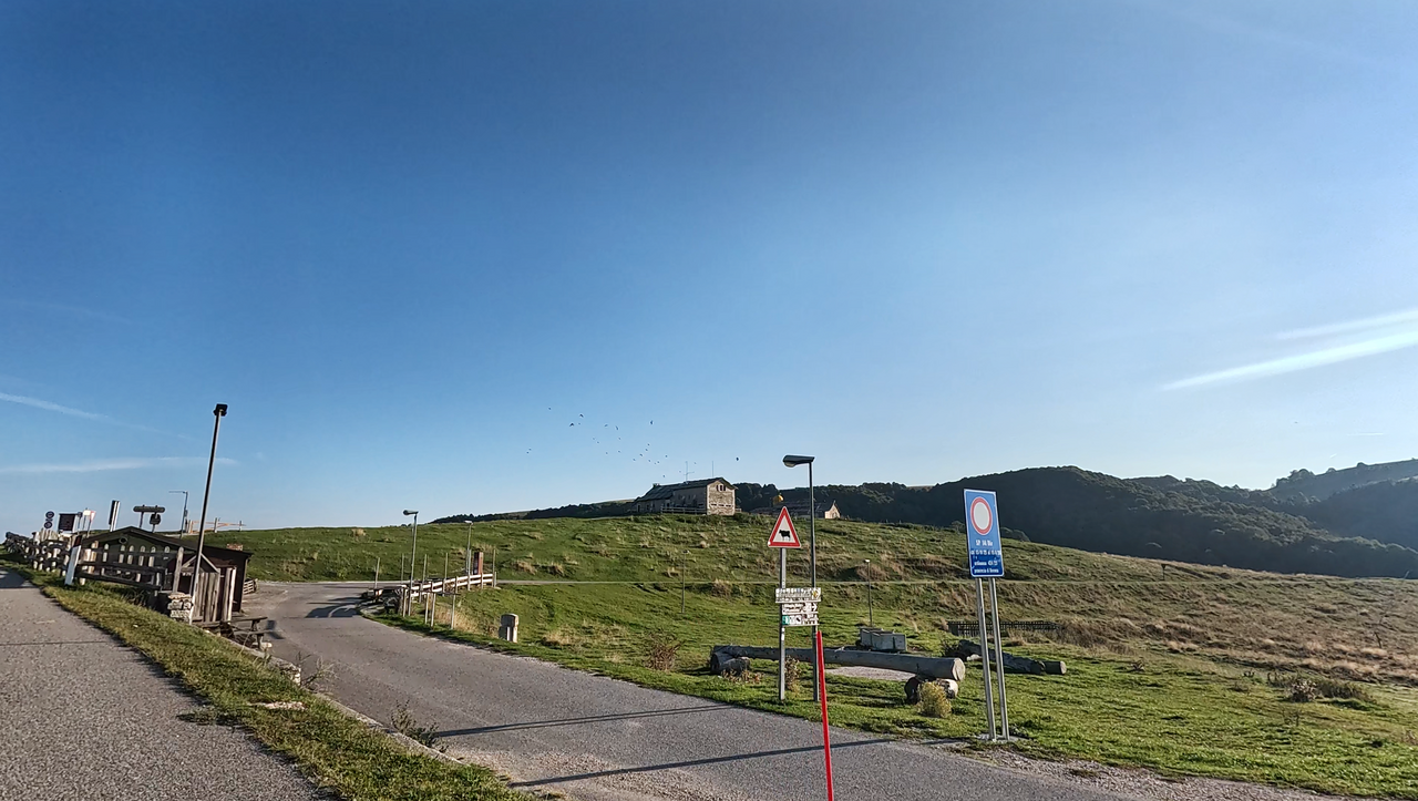 Almhütten und Almwiesen bestimmen das Bild der Passhöhe.